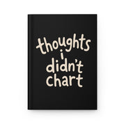 Mockup of a black hardcover journal front cover with cream lettering reading 'thoughts i didn't chart'