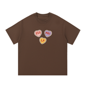 Mockup of a coffee brown cotton T-shirt with three candy hearts reading 'EEG', 'MRI' and 'LP'