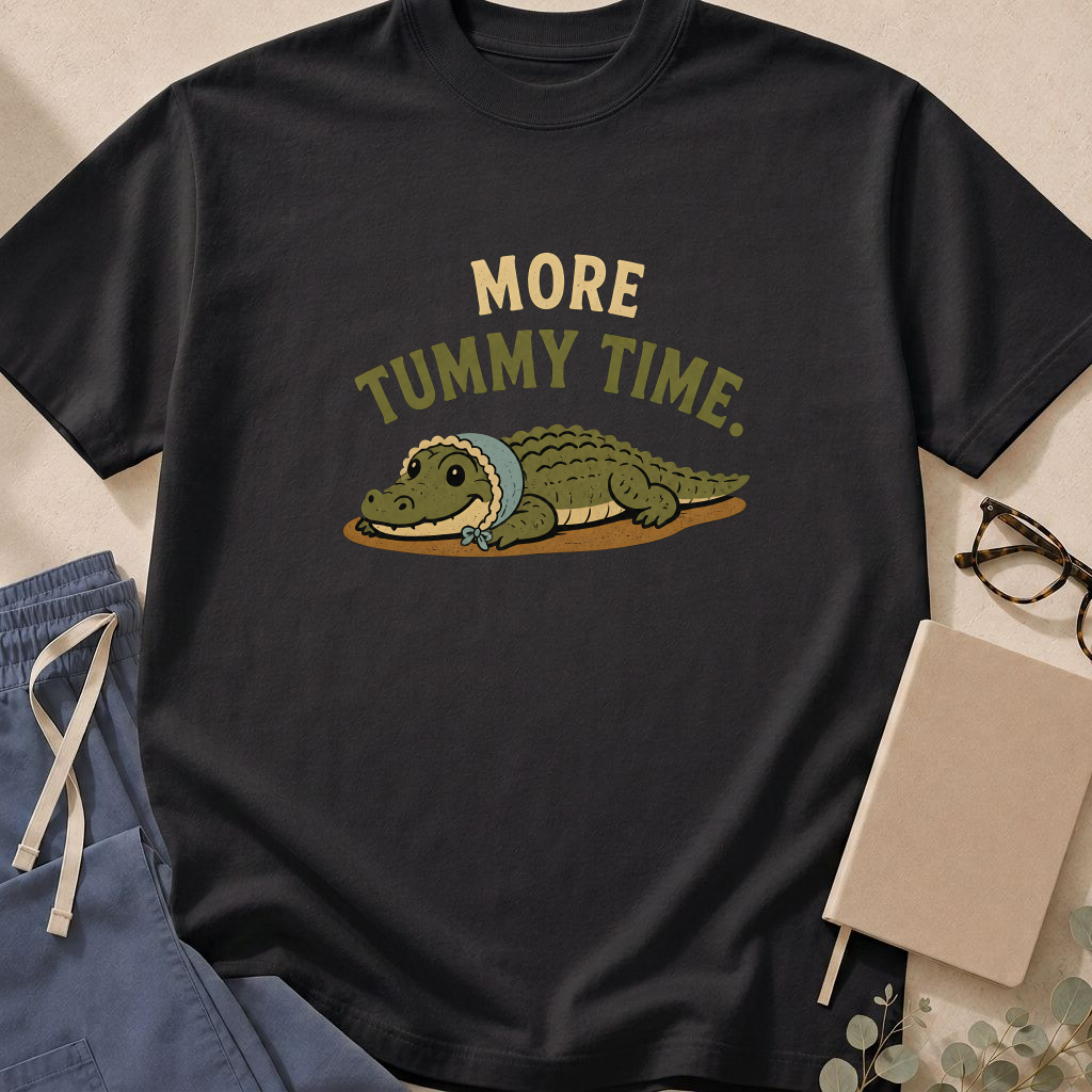 Garment-dyed unisex t-shirt printed with 'More Tummy Time' — pediatrics humor tee for peds providers.