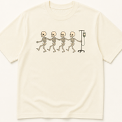 Garment-dyed unisex t-shirt featuring an illustrated Skeletons Doing Conga Line Pulling IV Pole design — Hospital Medicine humor tee for Nursing professionals.