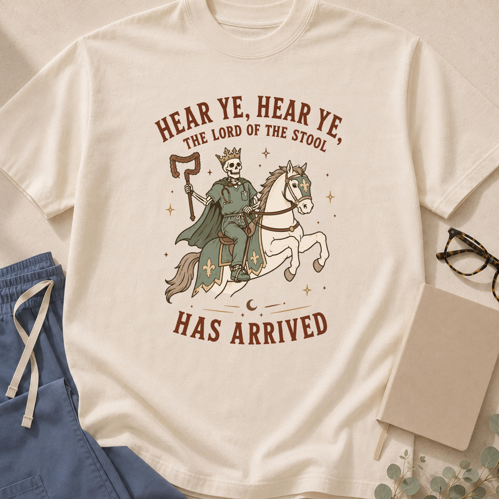 Garment-dyed unisex t-shirt printed with 'Hear Ye, the Lord of the Stool Has Arrived' — gastroenterology humor tee for GI doctors and nurses.