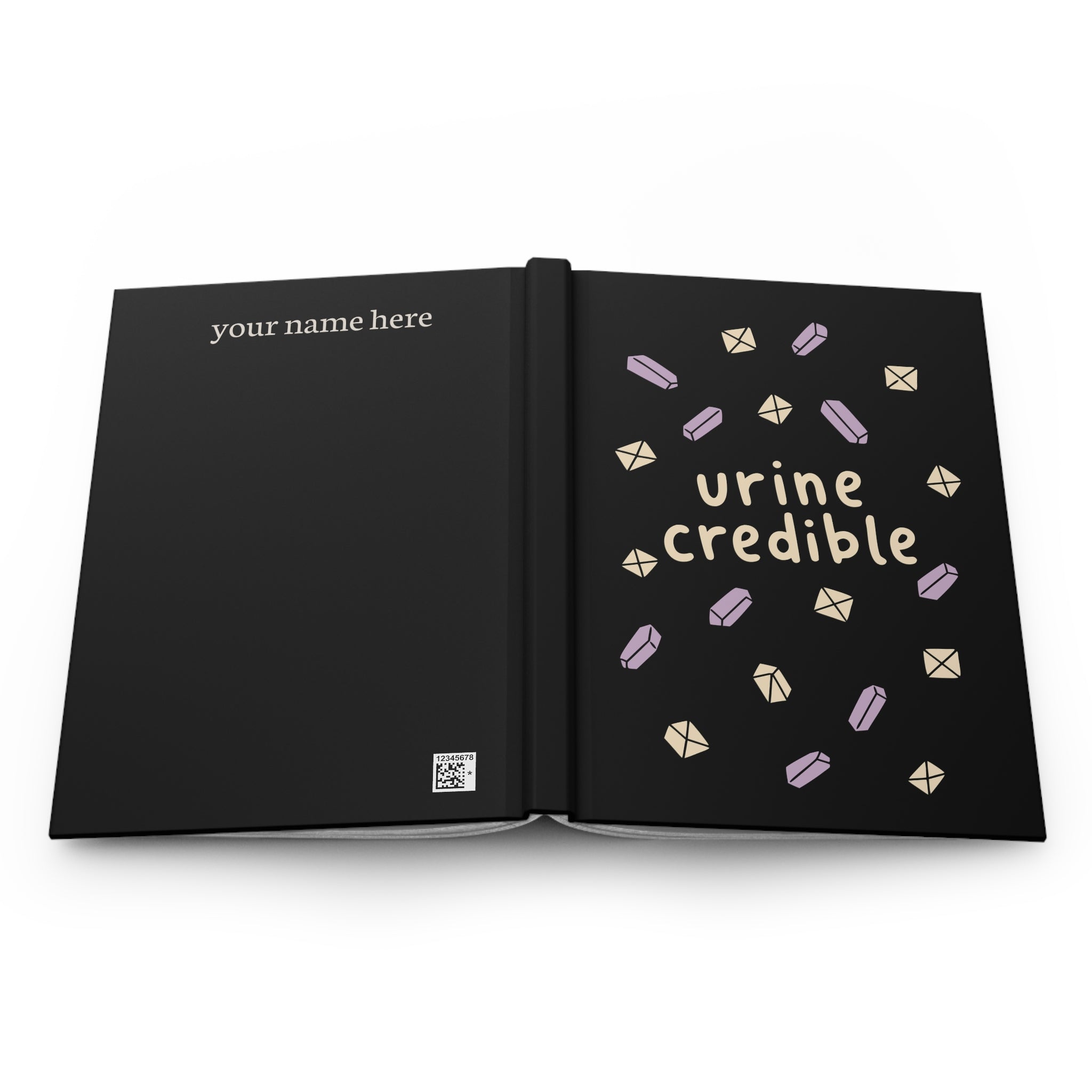 Black hardcover journal laid open flat, back cover 'your name here', front cover 'urine credible' with crystals