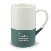 Mockup of a forest green and white speckled ceramic mug engraved "The black cloud has entered the building."
