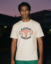 Man photographed with flash at night, wearing an apricot cotton T-shirt with the Fallopian Fabulous design.