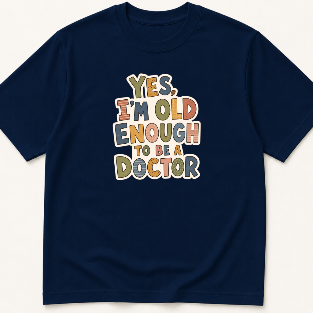 Garment-dyed unisex t-shirt printed with 'Yes, I'm Old Enough to Be a Doctor' — Attending humor tee for Family Medicine, General Medicine, and Internal Medicine professionals.