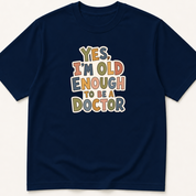Garment-dyed unisex t-shirt printed with 'Yes, I'm Old Enough to Be a Doctor' — Attending humor tee for Family Medicine, General Medicine, and Internal Medicine professionals.