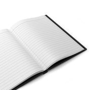 Open hardcover journal showing lined pages and a black cover edge