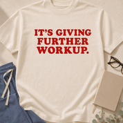 Garment-dyed unisex t-shirt printed with "It's Giving Further Workup" — internal medicine humor tee for hospitalists and residents