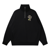 Mockup of a black quarter-zip sweatshirt with 'The gall of thee' lettered above a green hand-drawn gallbladder on the chest.