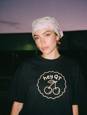 Woman photographed with flash at night, wearing a black cotton T-shirt with the 'Hey QT' design.