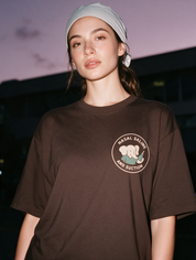 Woman photographed with flash at night wearing a coffee brown cotton T-shirt with 'Nasal Saline and Suction' design.