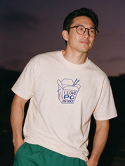 Man photographed with flash at night, wearing an apricot cotton T-shirt with the I Love PO Intake design.
