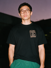 Man photographed with flash at night, wearing a black cotton T-shirt with the Scientific Literacy Is Hot design.