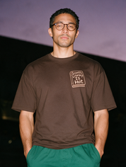 Man photographed with flash at night, wearing a coffee cotton T-shirt with the Scientific Literacy Is Hot design.