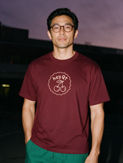Man photographed with flash at night, wearing a wine red cotton T-shirt with the Hey QT design.