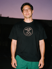 Man photographed with flash at night, wearing a black cotton T-shirt with the Hey QT design.