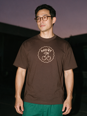 Man photographed with flash at night, wearing a coffee cotton T-shirt with the Hey QT design.