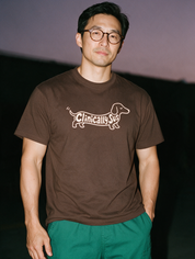 Man photographed with flash at night, wearing a coffee cotton T-shirt with the Clinically Sus design.
