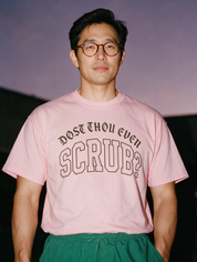 Man photographed with flash at night, wearing a pink cotton T-shirt with the Dost Thou Even Scrub? design.