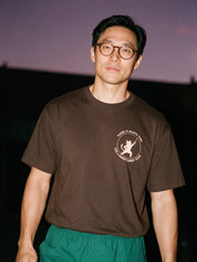 Man photographed with flash at night, wearing a coffee cotton T-shirt with the There Is Always Time for a Monofilament Exam design.