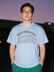 Man photographed with flash at night, wearing a blue cotton T-shirt with the Dost Thou Even Scrub? design.
