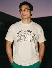 Man photographed with flash at night, wearing an apricot cotton T-shirt with the Dost Thou Even Scrub? design.