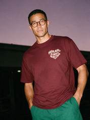 Man photographed with flash at night, wearing a wine red cotton T-shirt with the Normal Sinus Rhythm design.