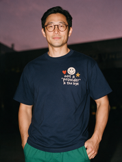 Man photographed with flash at night, wearing a navy blue cotton T-shirt with the Not a Provider, K Thx Bye design.